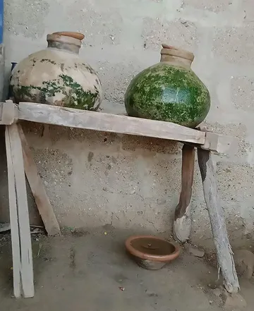 pitchers on old rusted wood stand in a village showing a culture of Asia