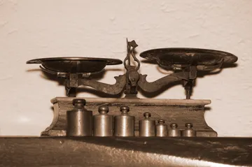 Close-up of antique weighing scale against wall